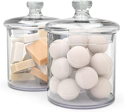 Kook Glass Apothecary Storage Jars (36 oz, Set of 2) with lids, one containing soap bars and the other with white spherical objects.