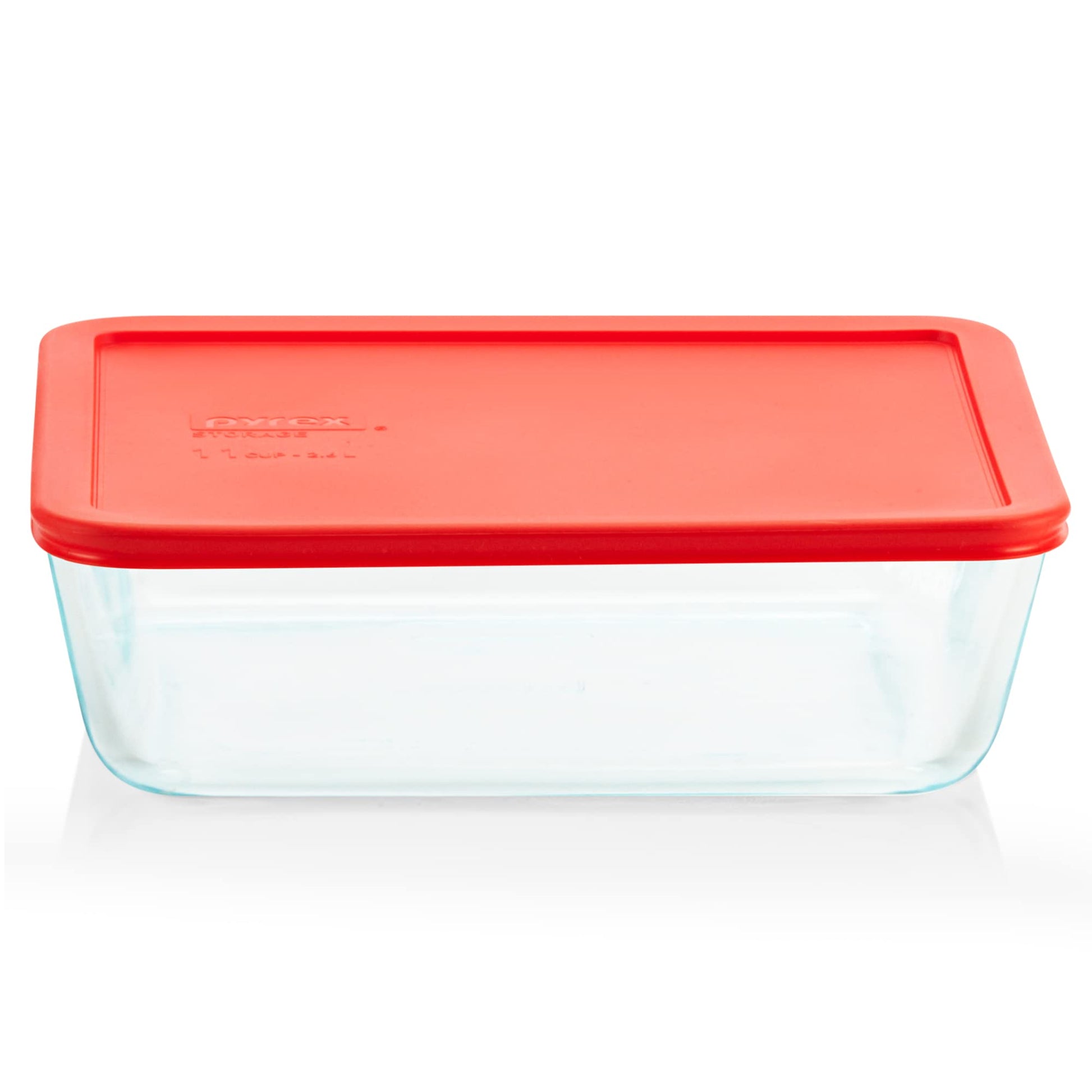 Pyrex glass food storage container with a red lid on a white background