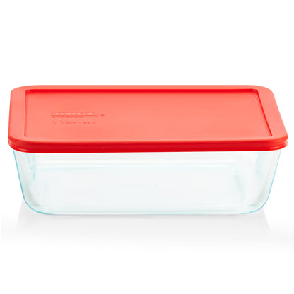 Pyrex glass food storage container with a red lid on a white background