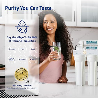 Woman holding a glass of water with a water filter system in the background