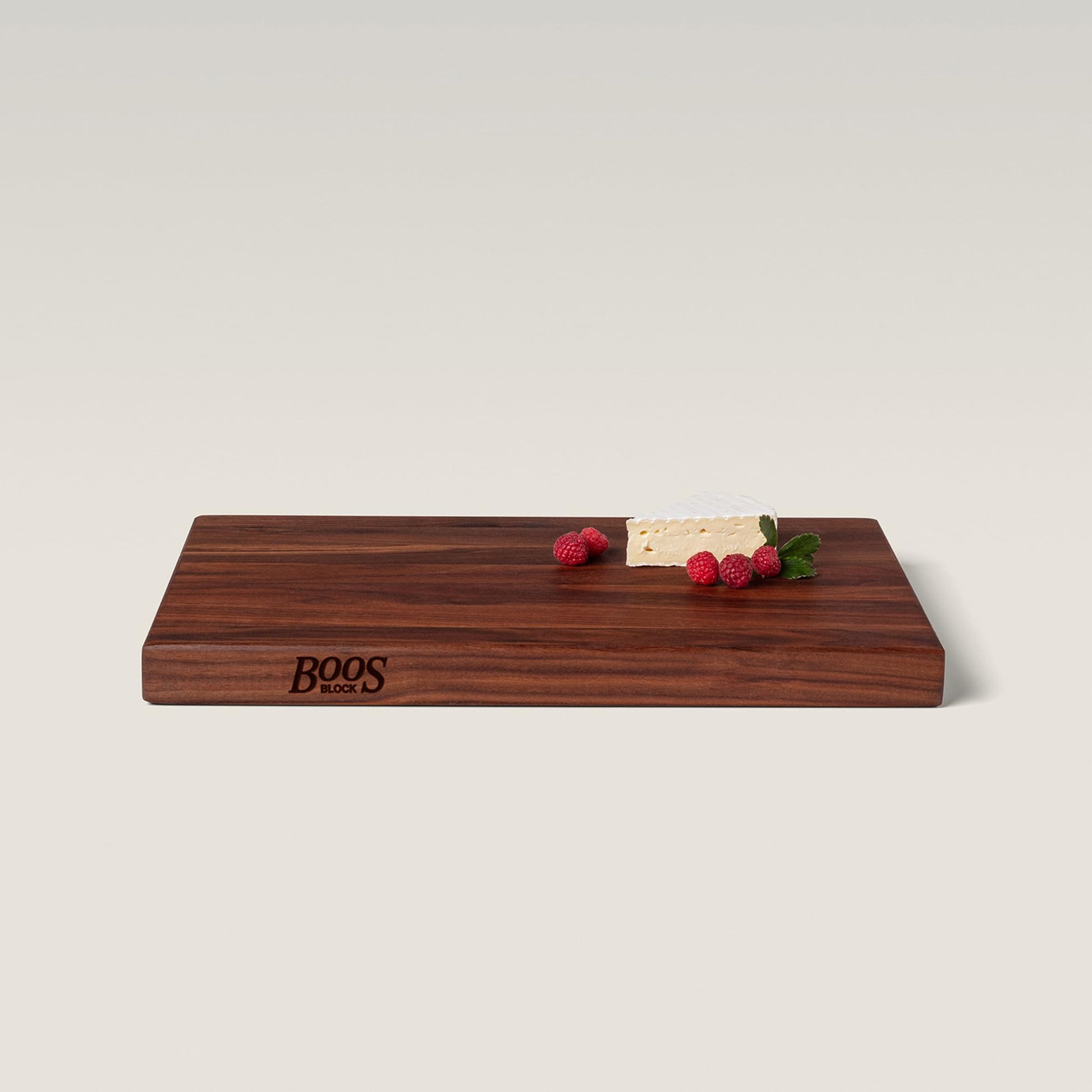 Wooden cutting board with 'BOOS' branding on a light background