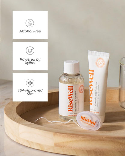 RiseWell products including a bottle, tube, and packets on a wooden tray with a neutral background.