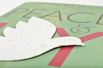 White dove cutout on a green background with 'PEACE' text