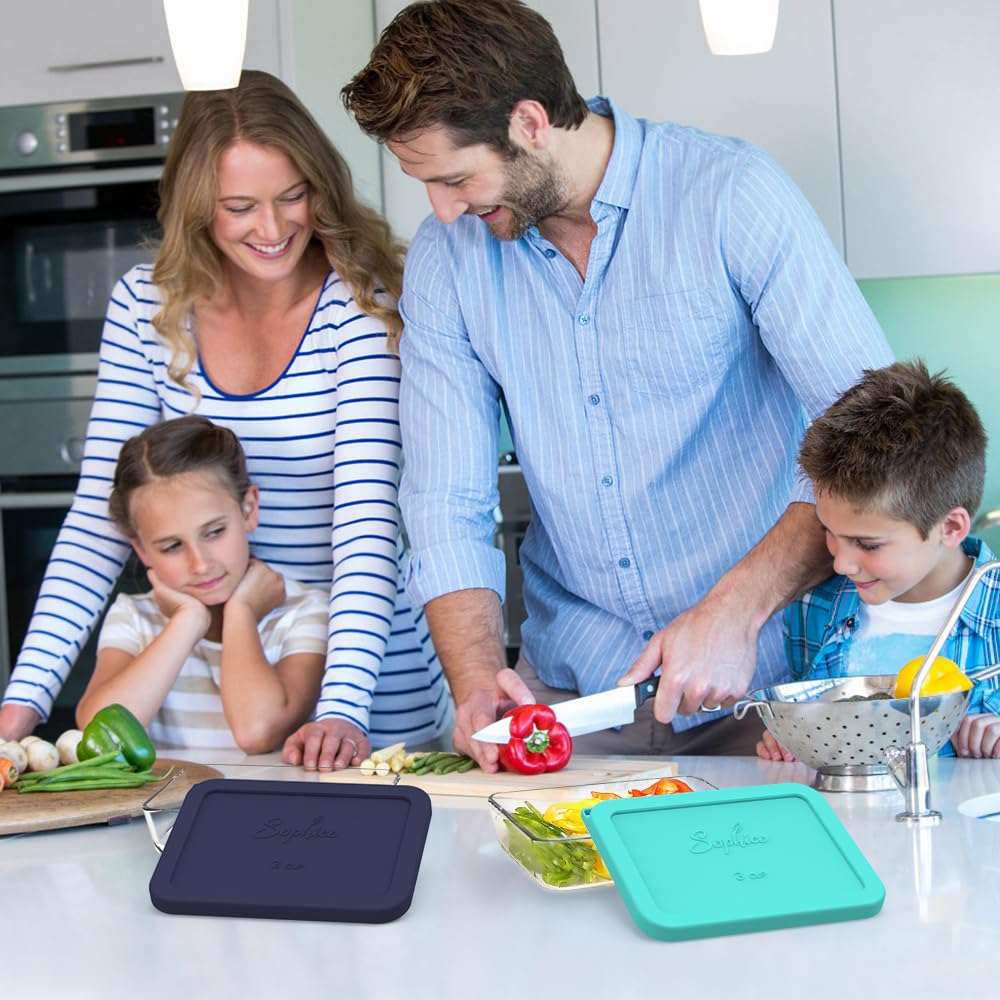 Family of four in a kitchen preparing food with cutting boards and vegetables.