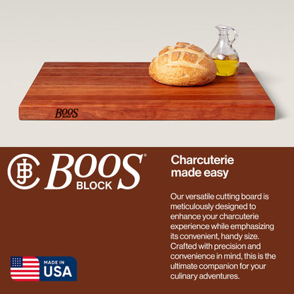 Wooden cutting board with bread and oil, Boos Block branding, and text about the product.