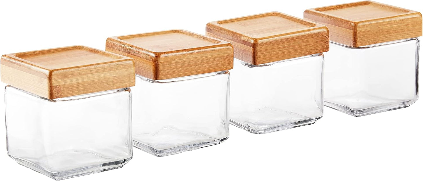 Four glass jars with wooden lids on a white background