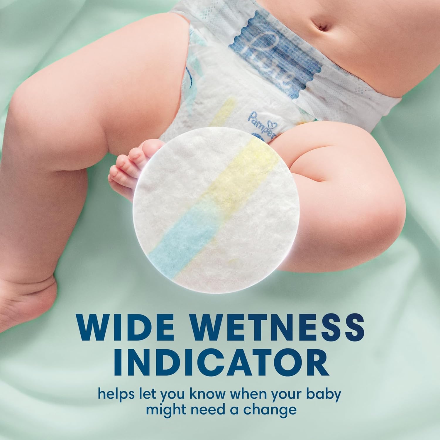 Baby holding a Pampers diaper with a wide wetness indicator on a light green background