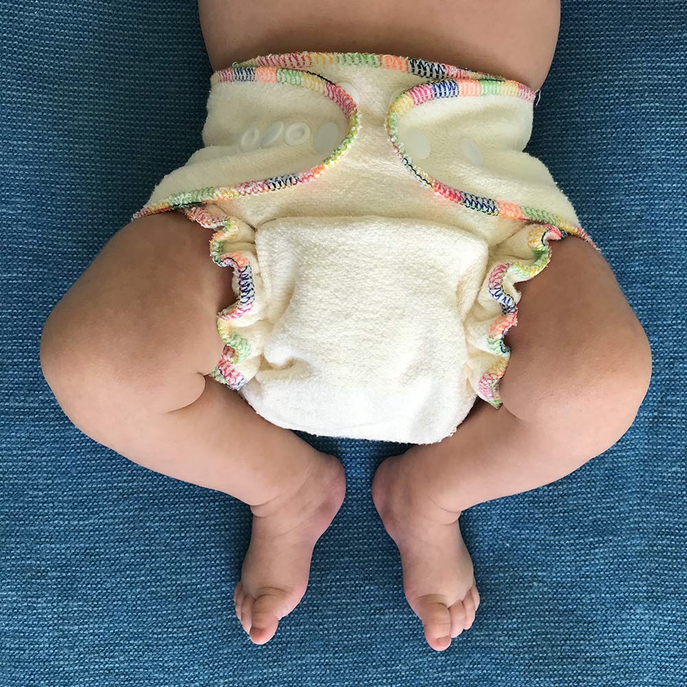 Baby wearing a colorful diaper on a blue textured surface