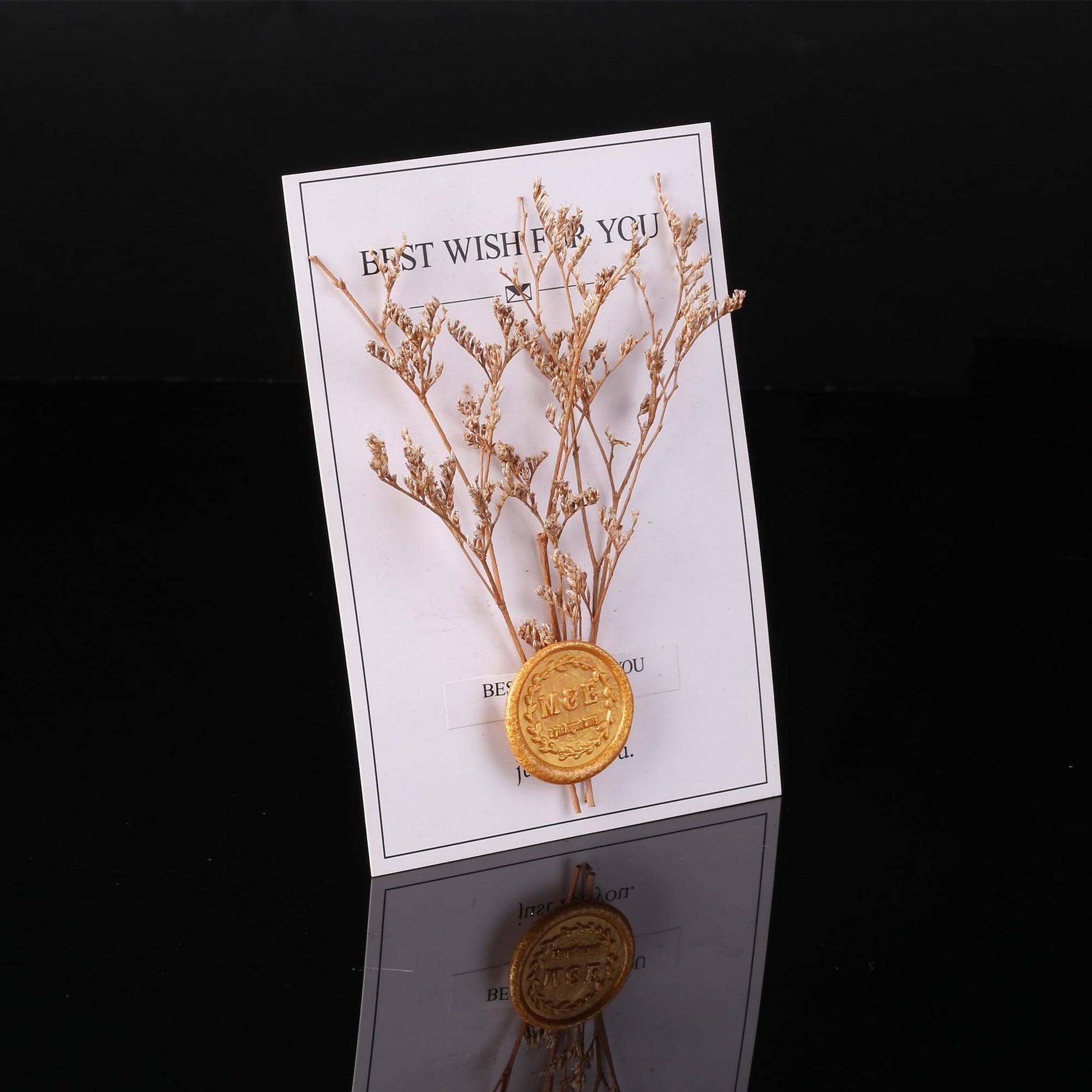 Decorative card with gold branches and a gold seal on a black background