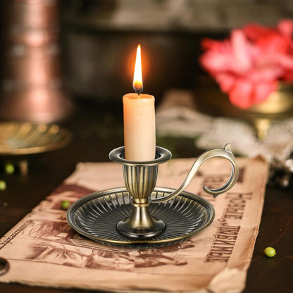 Candle in a decorative holder on a table with a blurred background