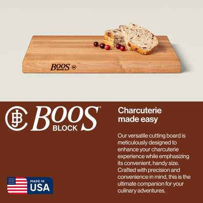 Wooden cutting board with bread and fruit on a beige background, featuring the Boos Block brand.