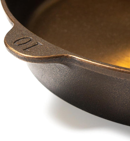 Close-up of a cast iron skillet with '01' marking on a white background