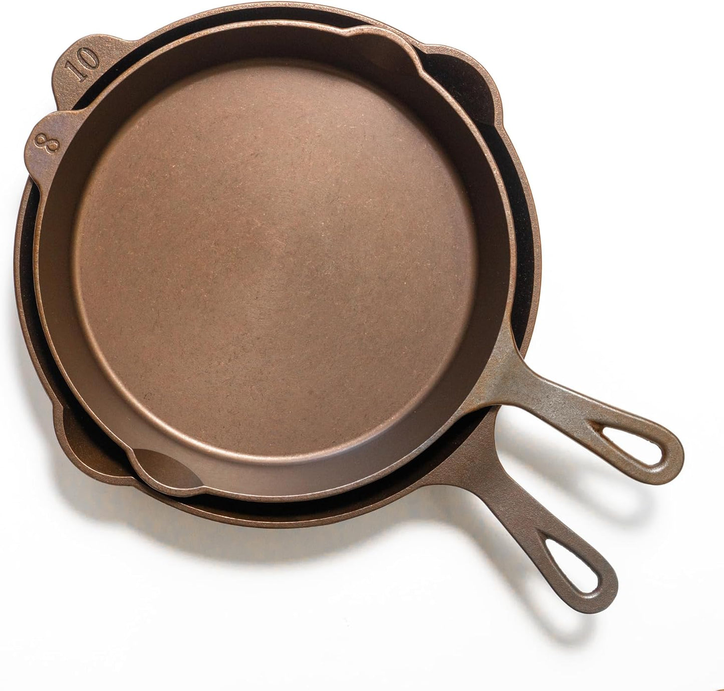 Set of three cast iron skillets on a white background