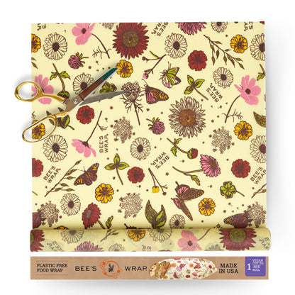 Bees wrap reusable food wrap roll of floral-patterned with scissors and packaging on a white background