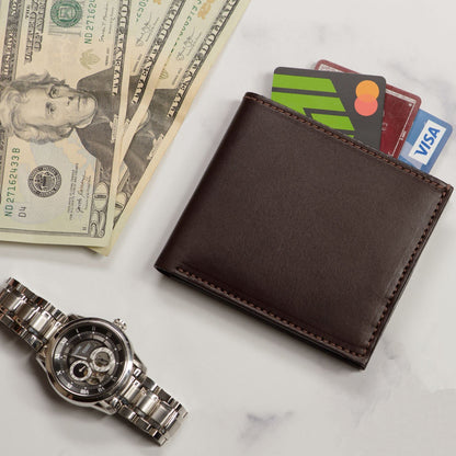 Brown leather wallet with cards, dollar bills, and a watch on a marble surface
