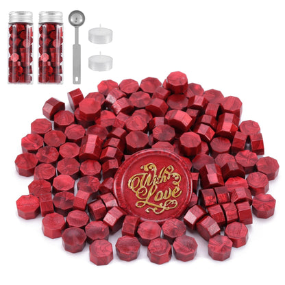 Red hexagonal sealing wax with a 'With Love' stamp, surrounded by small containers and tools on a white background.
