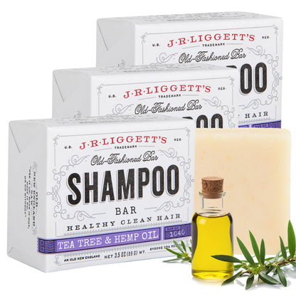 J.R. Liggett's shampoo bar packaging with a bottle of shampoo and tea tree leaves on a white background