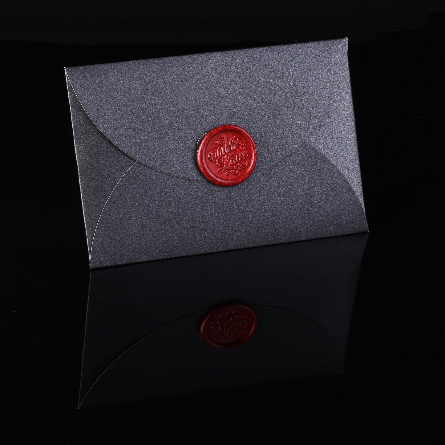 Gray envelope with a red wax seal on a black background