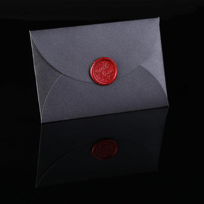 Gray envelope with a red wax seal on a black background