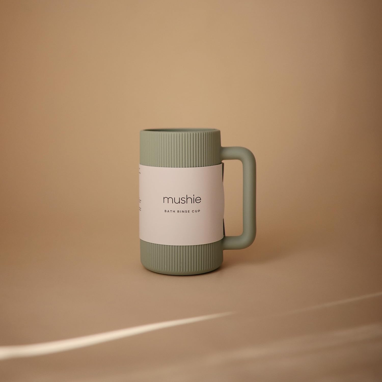 Green mug with handle on a beige background