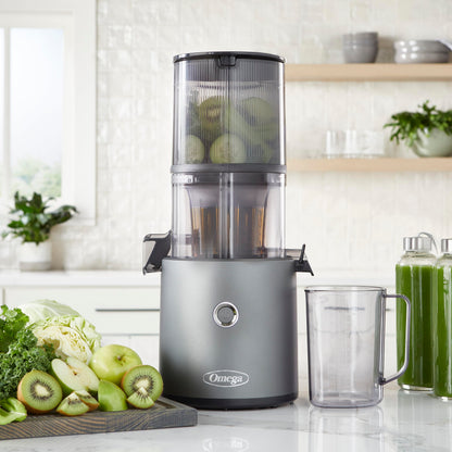 Omega Cold Press Hands-Free Juicer and a glass on a kitchen counter