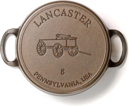Round metal plate with 'Lancaster, Pennsylvania, USA' text and cart illustration on a white background