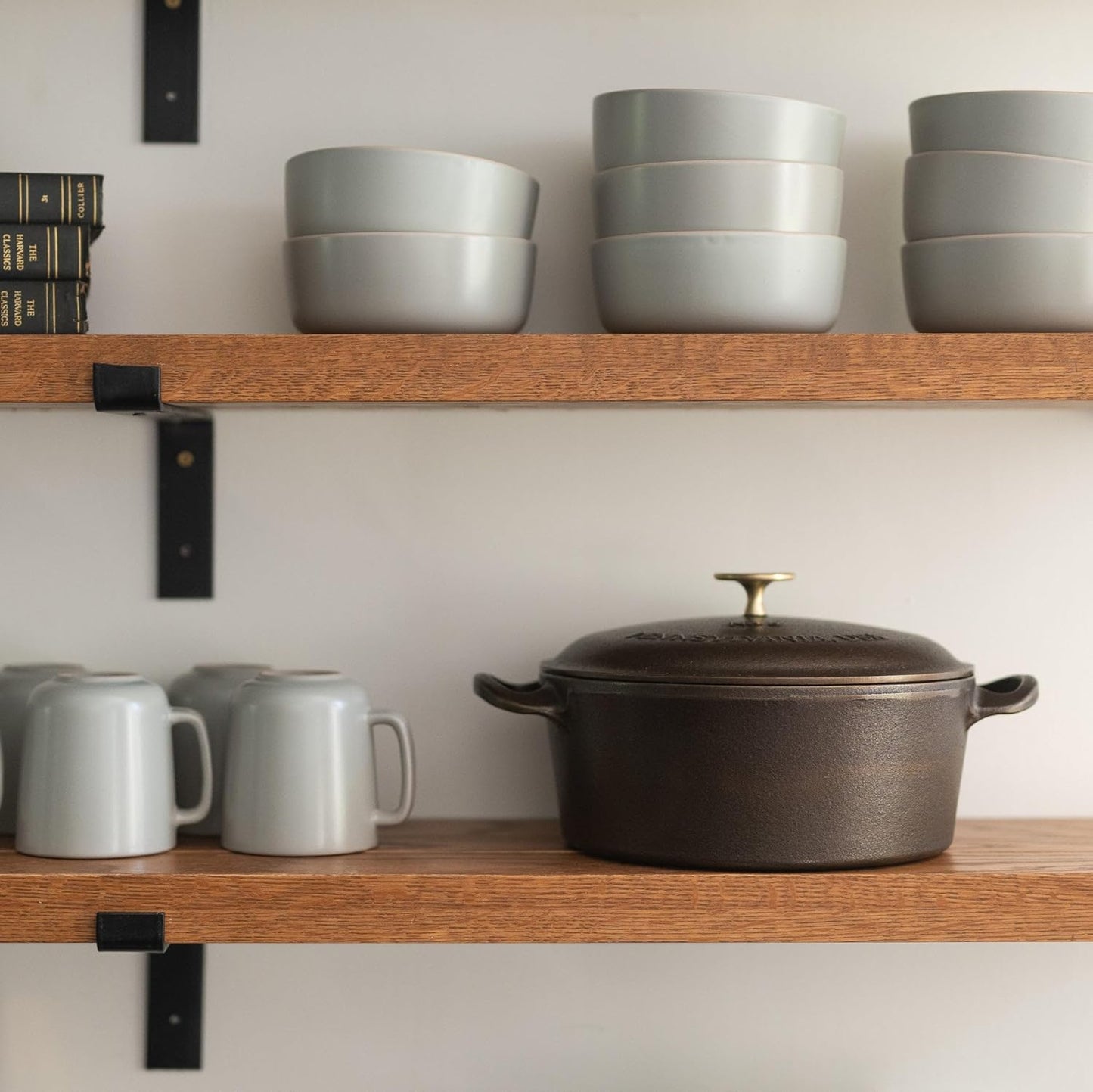 Wooden shelves with ceramic bowls and mugs on a neutral background
