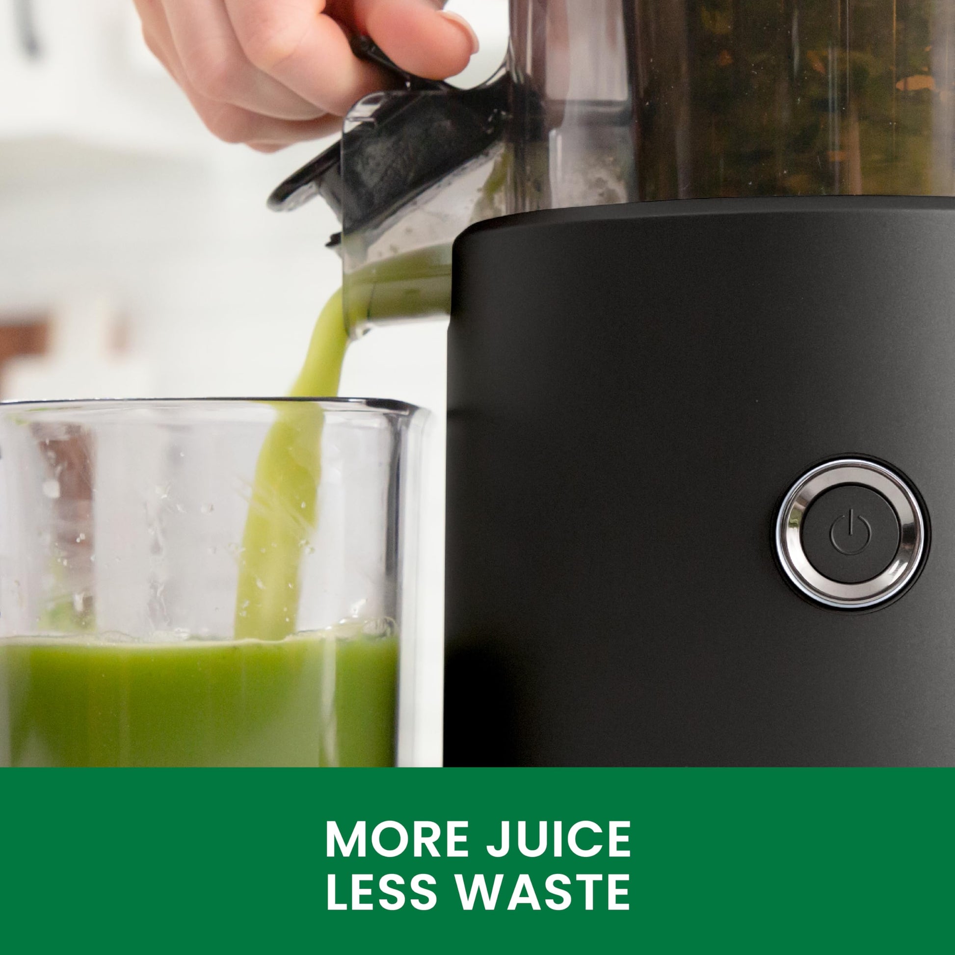 Black juicer with green juice being poured into a glass, featuring the text 'More Juice Less Waste'.
