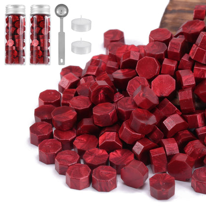 Red hexagonal sealing wax with containers, a spoon, and white candles on a white background