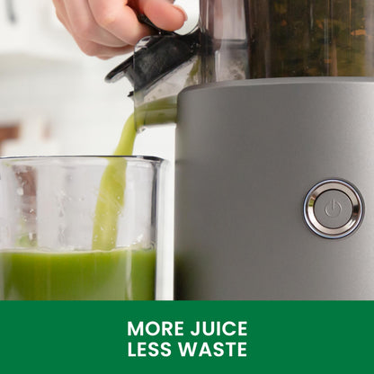 Gray juicer with green juice being poured into a glass, featuring the text 'More Juice Less Waste'.