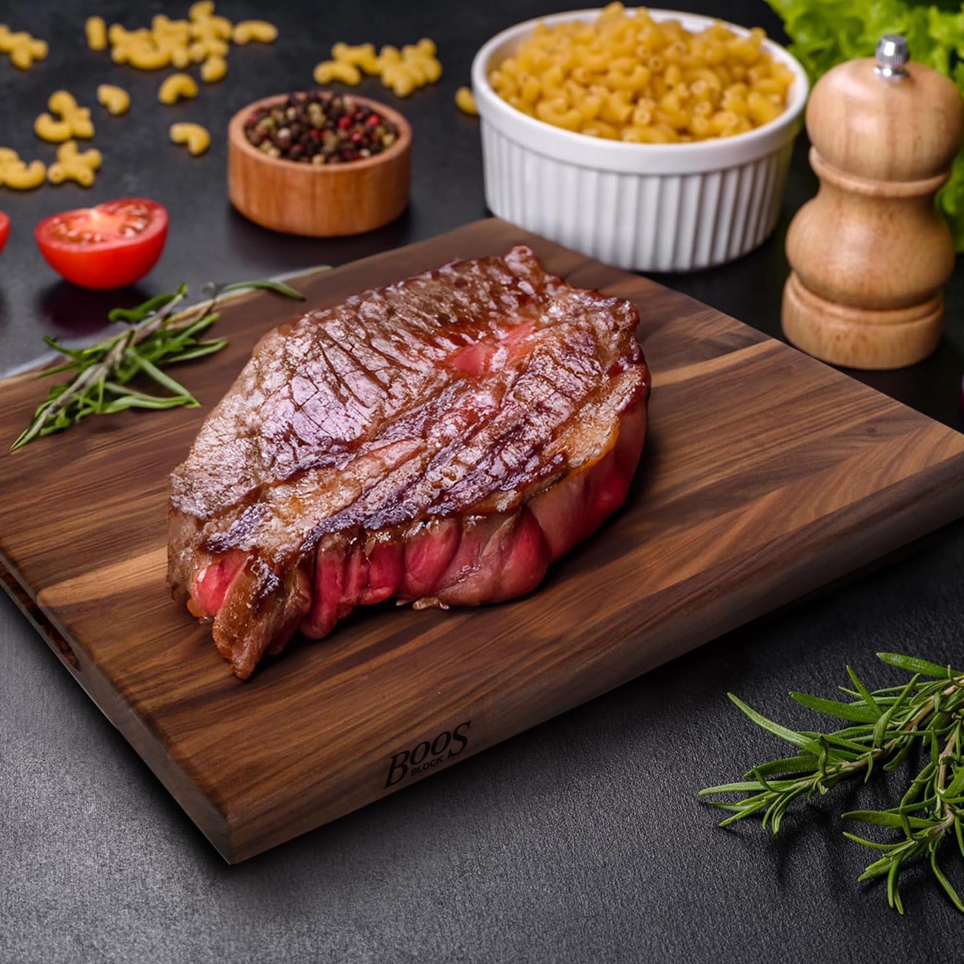 Grilled steak on a wooden cutting board with vegetables and pasta in the background
