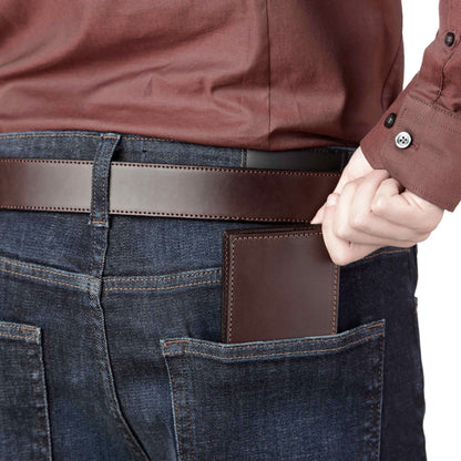 Person wearing a brown leather wallet in their jeans pocket with a white background