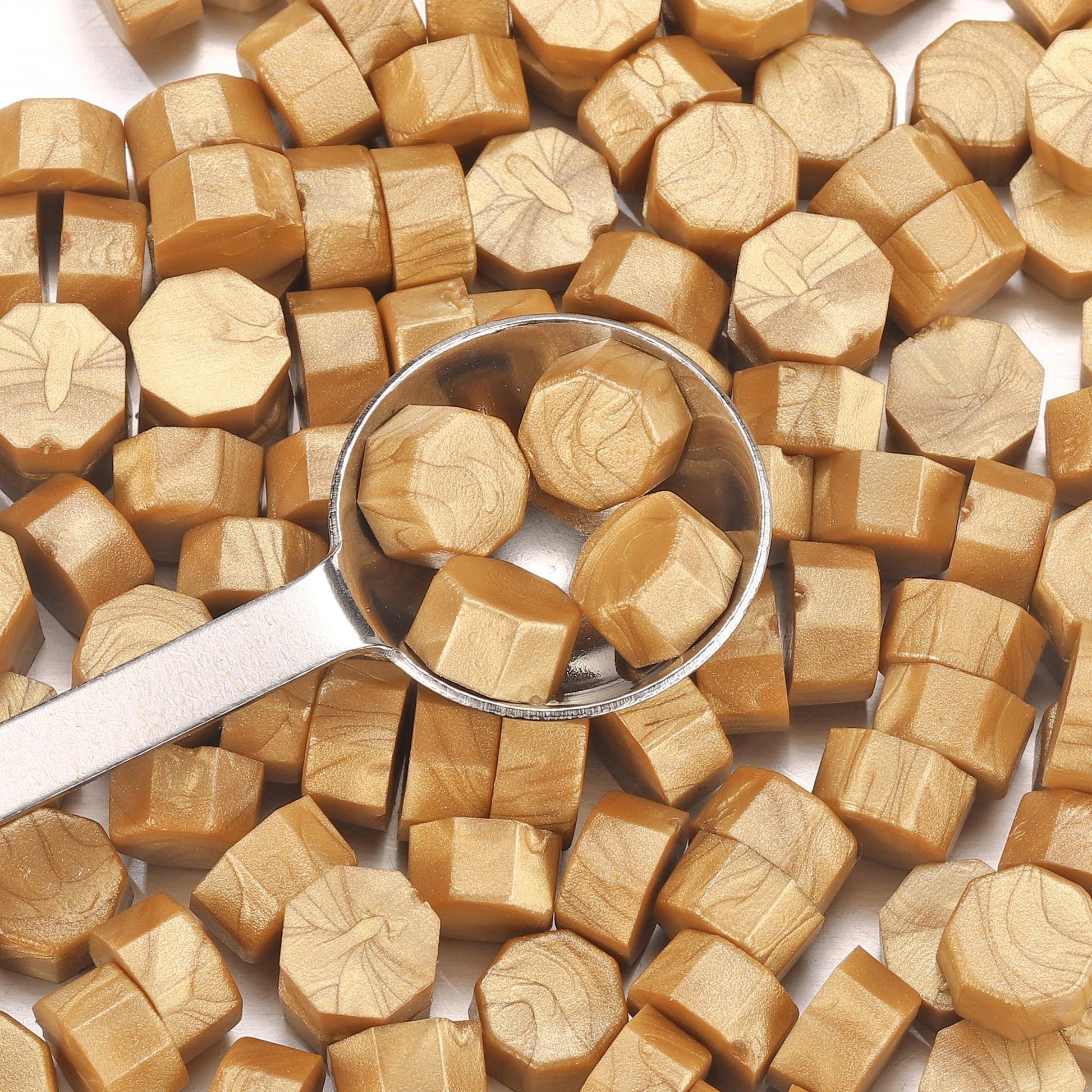 Spoonful of hexagonal brown sealing wax on a bed of brown sugar cubes.