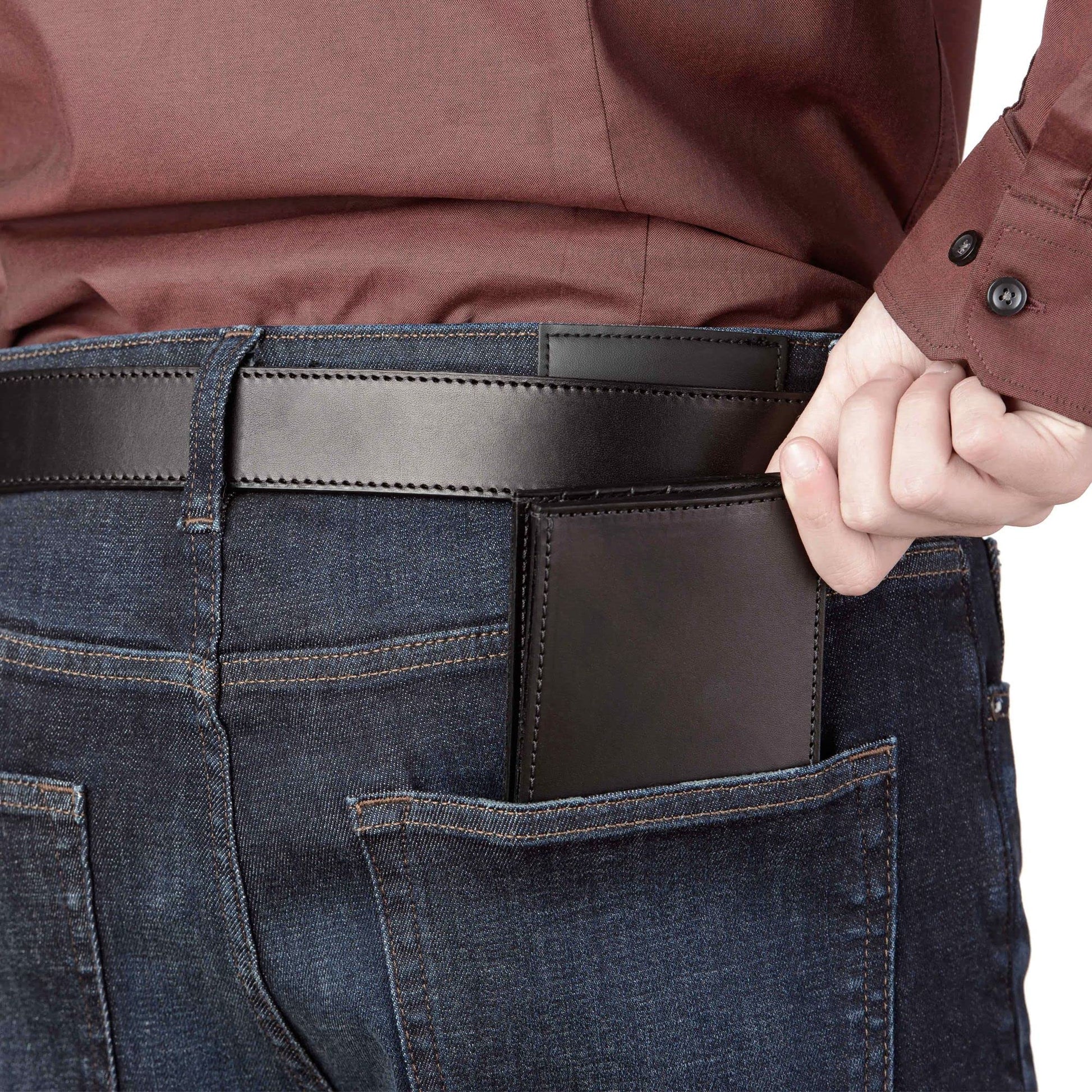 Person wearing blue jeans with a brown leather wallet in the back pocket, against a white background.