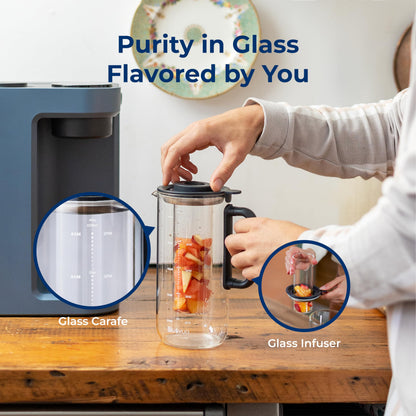 Person using a glass carafe and infuser with text 'Purity in Glass Flavored by You' on a wooden table.